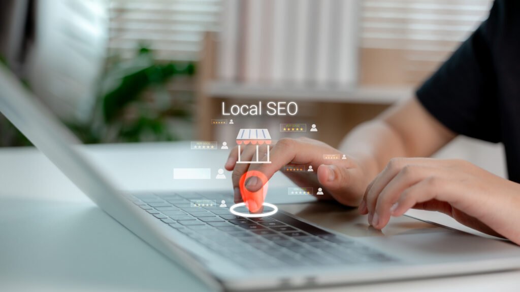 hand touching virtual location pin on laptop keyboard with local seo text and customer reviews, symbolizing local business marketing, online presence, and digital search optimization.